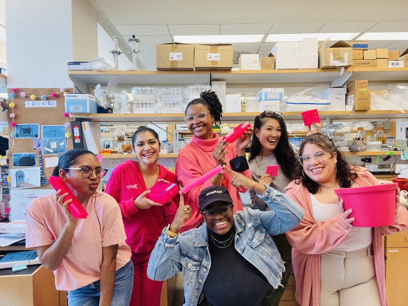 Spriggs Lab members wearing pink and holding pink lab supplies