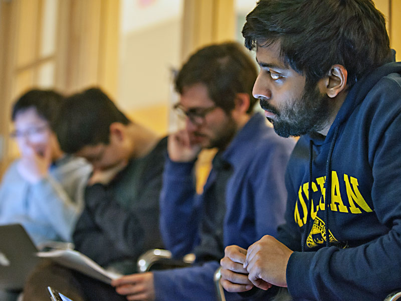 Man in Michigan sweatshirt listens during a seminar