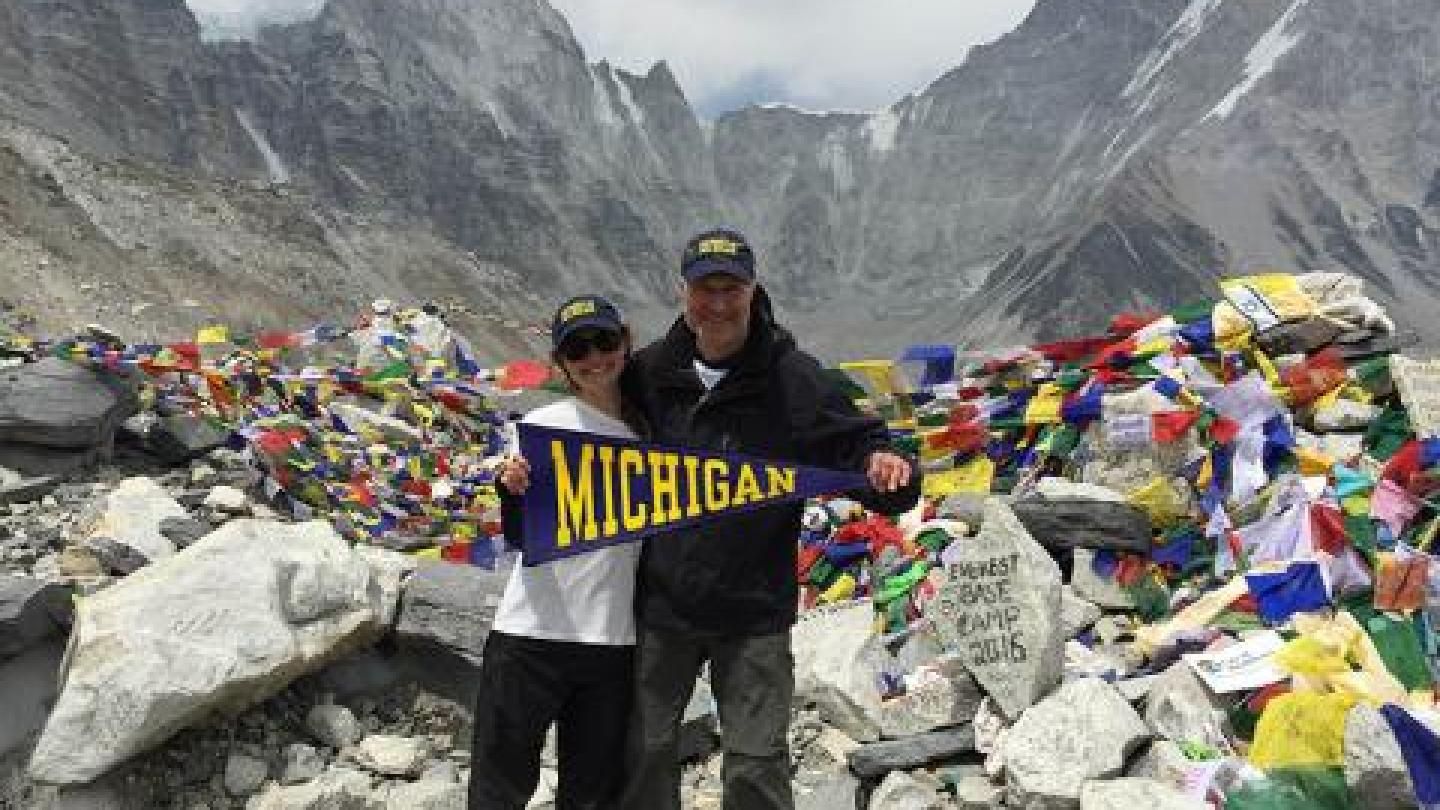 David Sherman and his daughter hold a U-M flag on Mt. Everest
